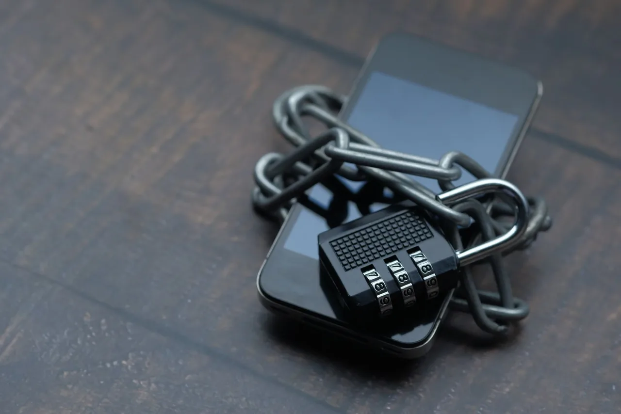 A smartphone wrapped with a security chain and padlock